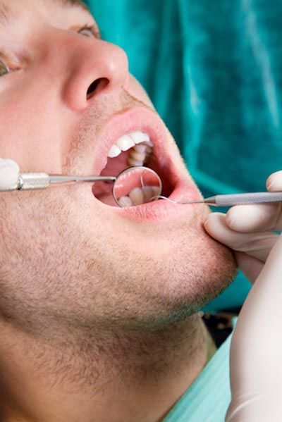 closeup of a dentist giving a patient a dental checkup