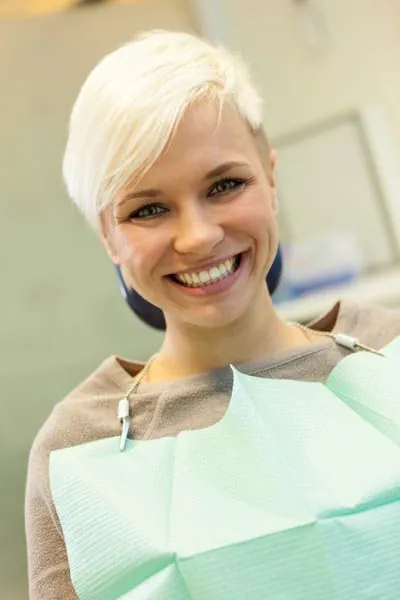 woman showing off her new dental bridge that helped restore her smile