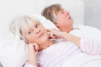 woman wide awake at night due to her husband's sleep apnea
